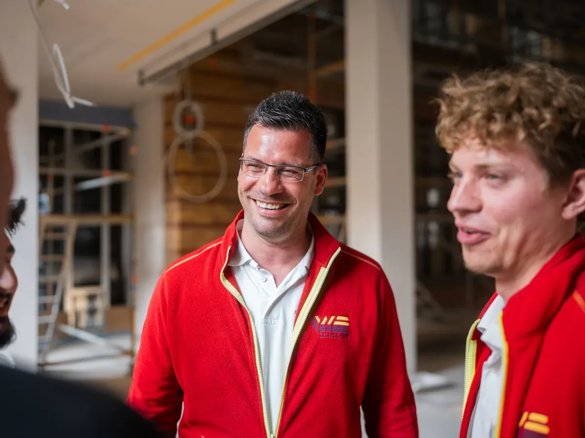 Bauleiter-und-Geselle-lachen-auf-der-Baustelle